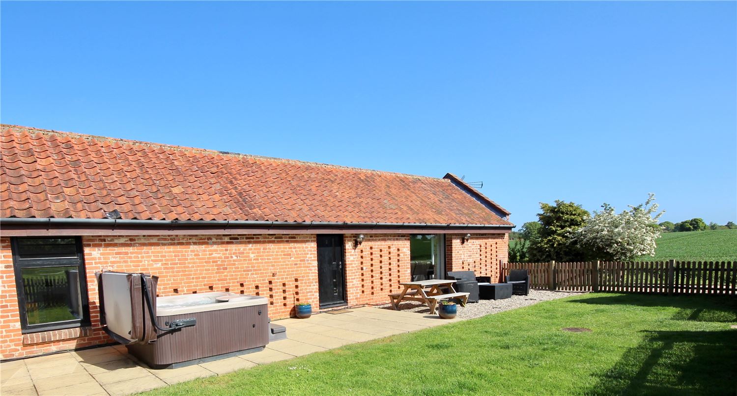Large enclosed outdoor garden with countryside views and hot tub at dog friendly Norfolk Broads holiday let sleeping 4