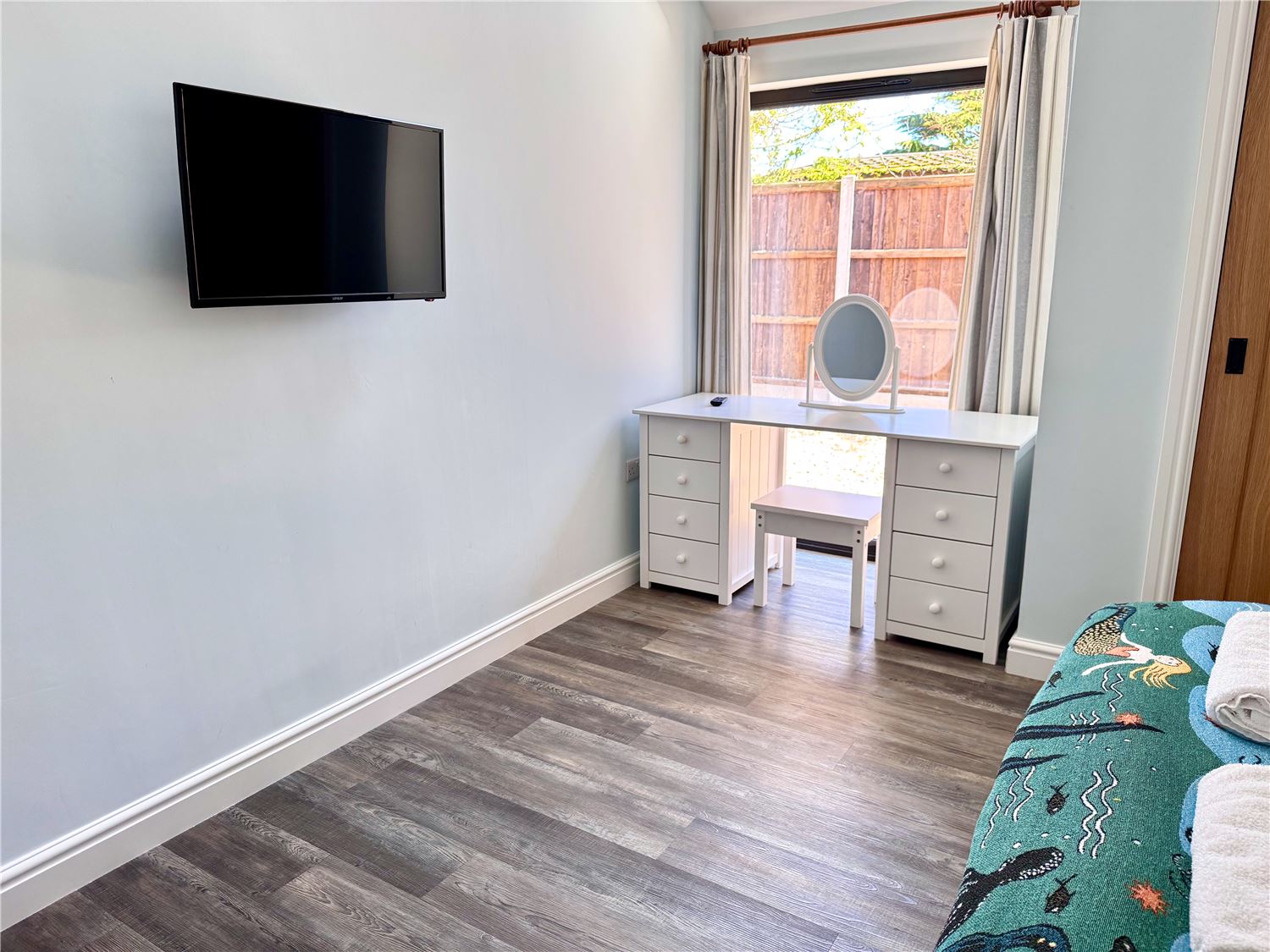 Kingsize bedroom with dressing table and TV at dog-friendly Norfolk Broads holiday cottage sleeps 6